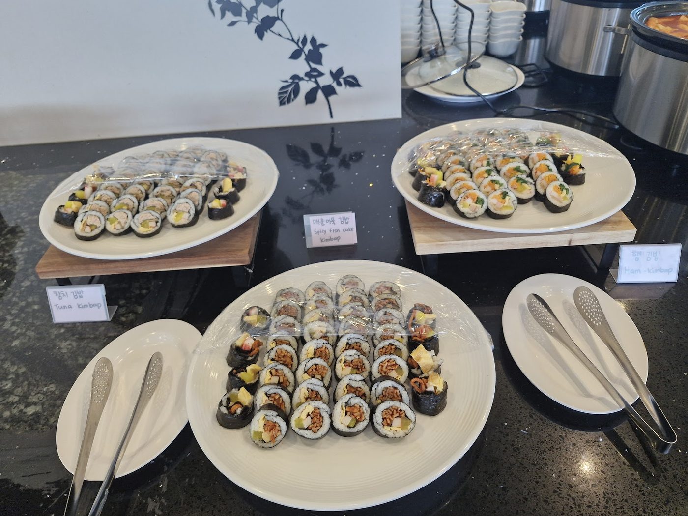 Plates of neatly arranged rolls and small dishes on a counter